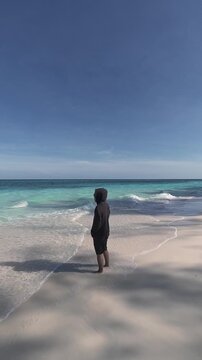 Person Standing on a Sandy Beach by the Ocean
