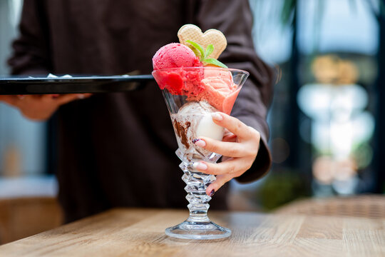 Waitress serves colorful ice cream dessert