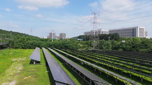 Aerial view of photovoltaic solar farm near city and transmission towers