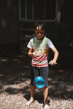 Young boy practicing diabolo skills outdoors in natural light. Childhood activity, concentration, coordination and playful learning in a relaxed outdoor setting.
