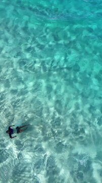 Aerial View of Man Swimming in Clear Turquoise Water