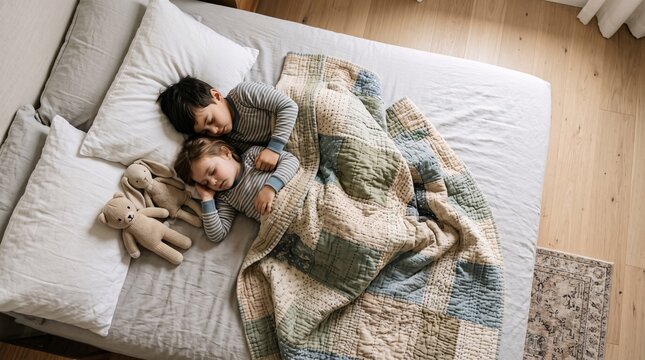 Two young siblings sleeping peacefully together in a cozy bed while clutching their soft stuffed animal toys during nap time