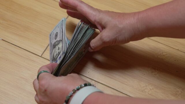Money dollars cash counting hundred banknote stack held by female hands for financial savings budget planning and banking investment concepts in office