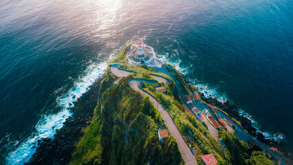 Arnel lighthouse illuminating sao miguel coast at dusk © Alberto