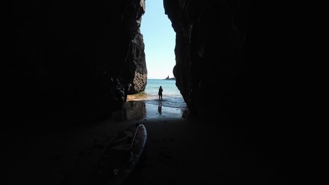 A woman running towards the sea, cliffs in Wales
