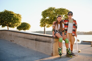 Fototapeta premium Happy kids having fun at the skate park. Concept of summer holidays and recreation