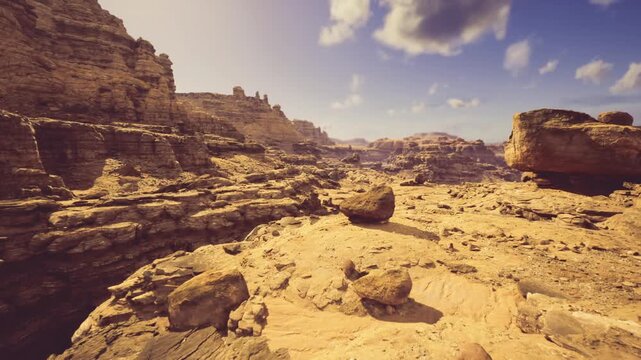 Layered sandstone canyon ideal for geology study, clear exposure of strata, sediment textures, weathering patterns and outcrops with broad valley context
