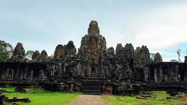 Majestic frontal view of the famous Bayon Temple in Angkor Thom, Cambodia, showcasing its iconic stone face towers and impressive Khmer architecture. Located within the UNESCO World Heritage-listed