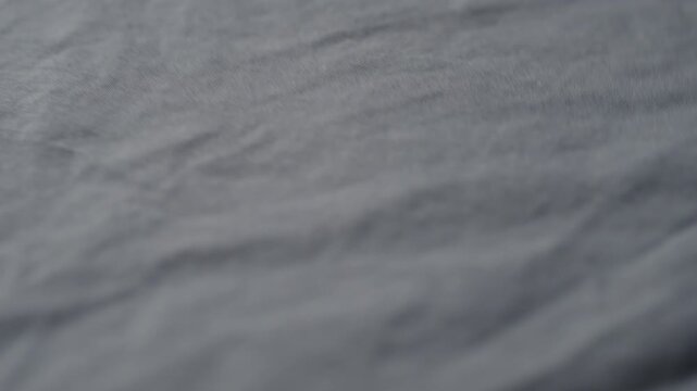 man manually check gray color cotton fabric for clothing with hands
