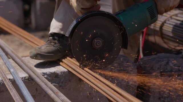 Cutting steel rebar with angle grinder at construction site