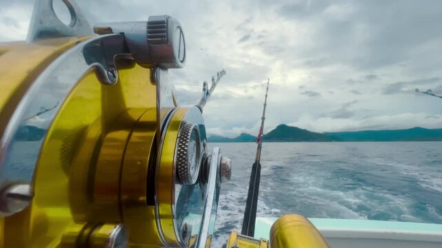 Big game fishing reel on boat rod in ocean water natural setting in 4K Ultra HD footage
