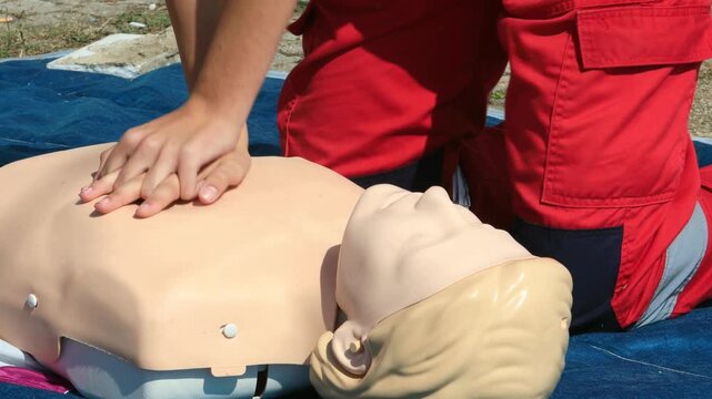 Paramedic Performing CPR Chest Compressions on a Training Manikin During First Aid and Resuscitation Training
