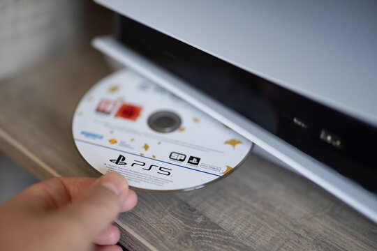 BRECHT, BELGIUM &ndash; July 10, 2026 Detailed macro shot of the PlayStation 5 optical drive with a game disc being inserted, highlighting gaming accessories and console technology.