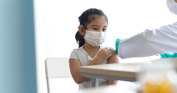 Asian little girl getting dengue vaccine. Pediatrician. pediatric checkup in hospital children medical care Doctor pediatric holds an injection vaccination the child.