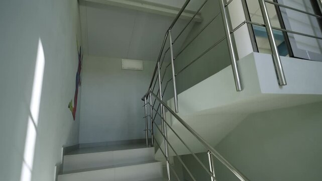 Multi level stairs connect corridors under paneled ceiling structure. Quiet environment emphasizes high hygienic standards of office