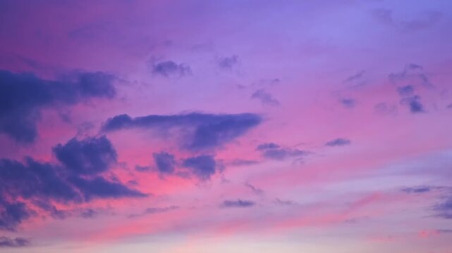 Morning or evening sky. Colorful clouds fill twilight with gradients of purple and pink during sunset or sunrise. Natural background. Beauty in nature. Expressive cloudscape. High quality 4K footage.