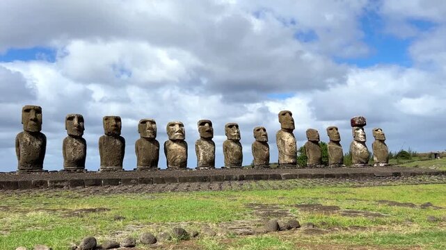 Daytime view of Ahu Tongariki on Easter Island, Chile. Fifteen iconic Moai statues standing against a bright blue sky and the Pacific Ocean. Famous archaeological site and UNESCO World Heritage 