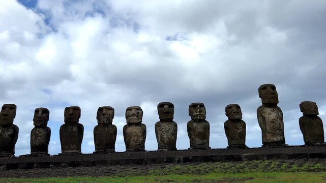 Daytime view of Ahu Tongariki on Easter Island, Chile. Fifteen iconic Moai statues standing against a bright blue sky and the Pacific Ocean. Famous archaeological site and UNESCO World Heritage 