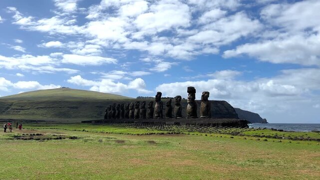 Daytime view of Ahu Tongariki on Easter Island, Chile. Fifteen iconic Moai statues standing against a bright blue sky and the Pacific Ocean. Famous archaeological site and UNESCO World Heritage 