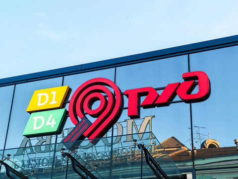 Moscow, Russia - June 21, 2026: Brightly colored sign of the Russian railway company RZD with directional indicators D1 and D4 displayed on a modern glass building