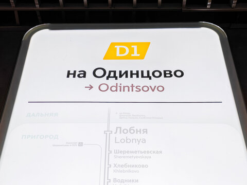 Moscow, Russia - June 21, 2026: D1 train line sign displaying direction to Odintsovo with station names in Cyrillic and English, illuminated in a modern subway setting