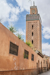 Fototapeta premium Minaret Base Above a Red Ochre Alley Wall at the Great Mosque, Fes el-Jdid, Morocco