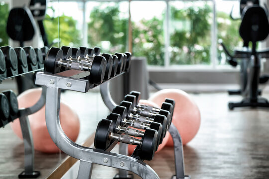 Dumbbell rack rows weight training equipment modern gym. Concept of free weights workout, healthy active lifestyle, bodybuilding and strength conditioning.