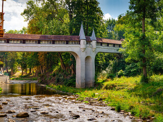 2025-09-01  Historic covered bridge with towers over a river in Ladek Zdroj Poland. © fotomaster