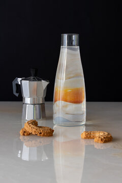 coffee pot and glass bottle with egg, cookies, on a marble table