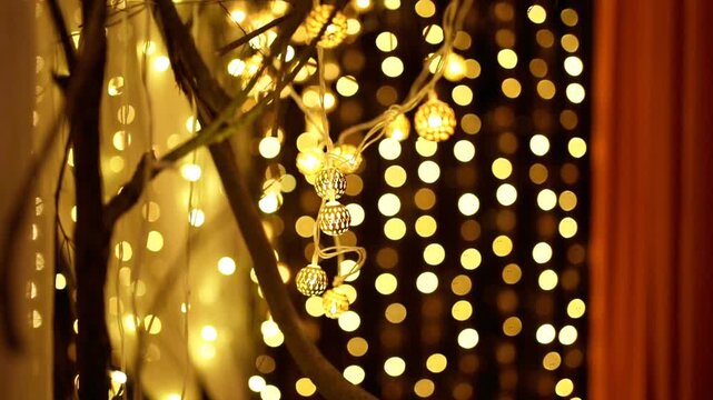 Close up of decorative orb string lights glowing against a soft golden bokeh background. Romantic and cozy festive ambiance lighting for wedding, holiday, or home decor.