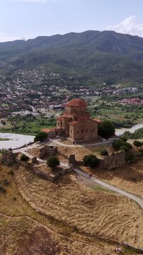 Aerial view of the ancient jvari monastery overlooking the city of mtskheta and the confluence of the aragvi and mtkvari rivers with a mountainous background in georgia