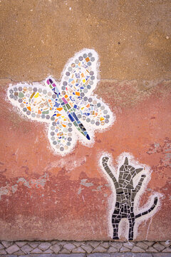 Wall mosaic of butterfly and cat in Olh&atilde;o, Portugal