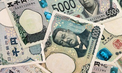 Japanese yen money banknotes pile on table. Japan bills of JPY currency. Concept of economy © Larysa
