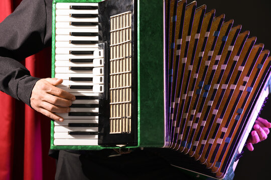 Man playing piano accordion on stage, closeup