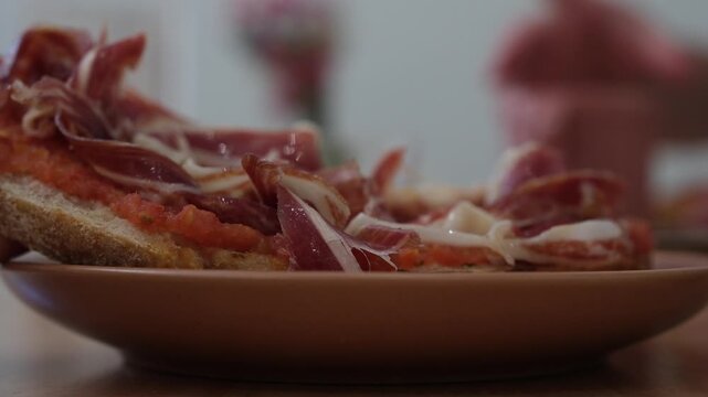 Close-up of traditional Spanish pan con tomate with jam&oacute;n in a caf&eacute; in Santander, Spain. Shallow depth of field.
