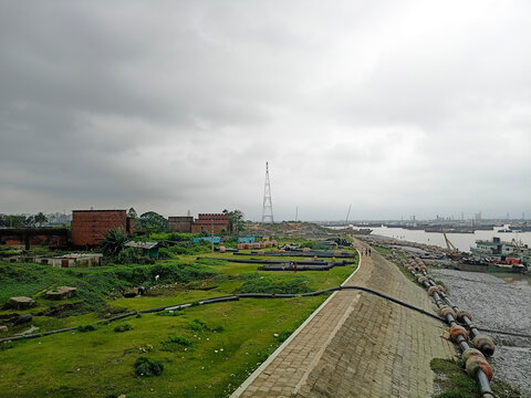Industrial Embankment with Dredging Pipes and River Infrastructure Under Overcast Sky