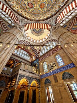 Low angle interior view of the magnificent Selimiye Mosque in Edirne, Turkey, showcasing the ornate marble minbar (pulpit), grand arches with red and white voussoirs, Islamic calligraphy