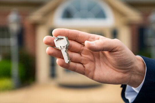 Property insurance. Real estate market. Broker man. House insurance. Realtor offering new home. Realtor in suit hold key outdoor. Real estate agent showing house for sale property