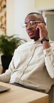 Multitasking, phone call and man with laptop in business, headhunter and communication with contact. Happy, recruiter and black person with technology, talking and planning for interview with mobile