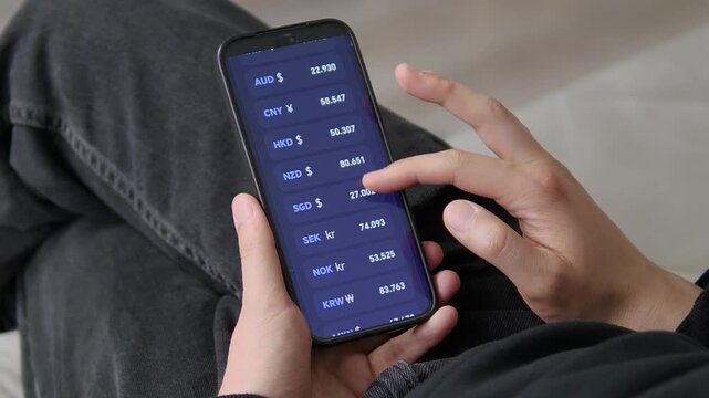 Real-time global currency monitoring on a smartphone. Browsing world rates for CHF, INR, and AUD in a comfortable casual setting. Great for international business, foreign exchange