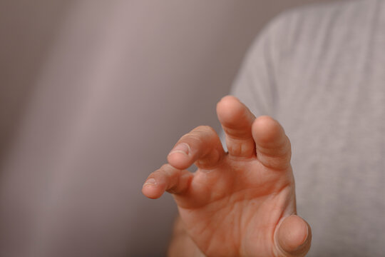 A person's hand extends forward, fingers slightly curled.