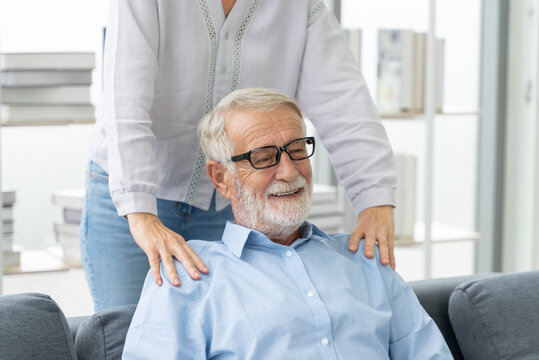 Happy senior man with caregiver supporting his shoulders at home.