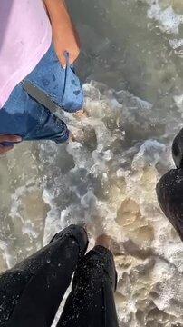 Friends' Feet Splashing in Sea Water, Mindfulness and Relaxation on Beach