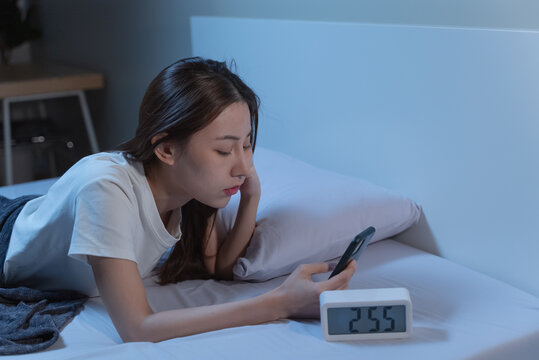 Asian women opened eyes lying on the bed have an insomnia problems.