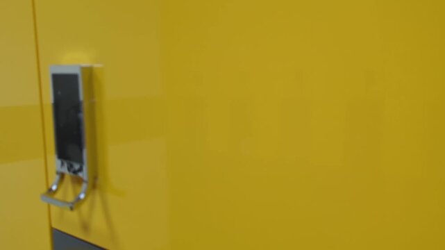 electronic lock on a bright yellow locker in a changing room. Perfect for fitness, gym, spa, and security