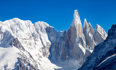 Naklejka premium Majestic view of the sharp granite spire of Cerro Torre surrounded by glaciers and snow-covered mountains in Los Glaciares National Park, Patagonia, Argentina.