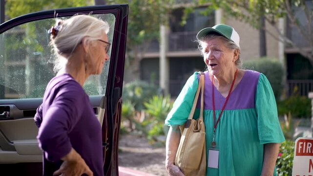 An elderly mother and her mature daughter embrace and say goodbye outside a care facility with love and warmth in their hearts.