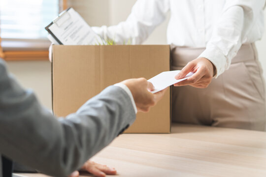 Unemployment quitting job, desperate asian young business woman send resignation letter to boss, resigning from company,holding belongs, pack stuff in box, layoff or leaving, changing work employment