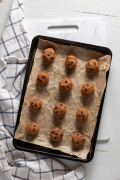Rows of homemade peanut butter chocolate chip energy balls on baking sheet.