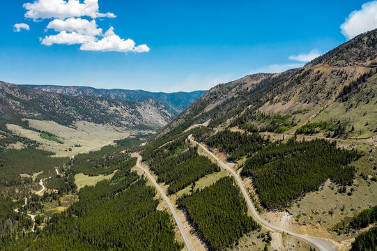 Roads on the slopes in high Montana mountains, blue clear sky with few clouds, summertime